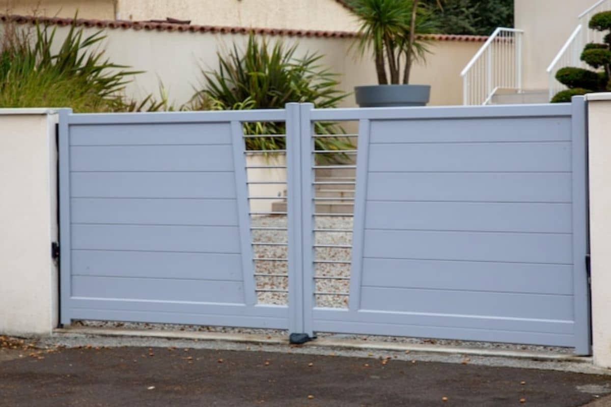 ประตูรั้วบ้านสีเทาที่เข้ากับกำแพงบ้าน